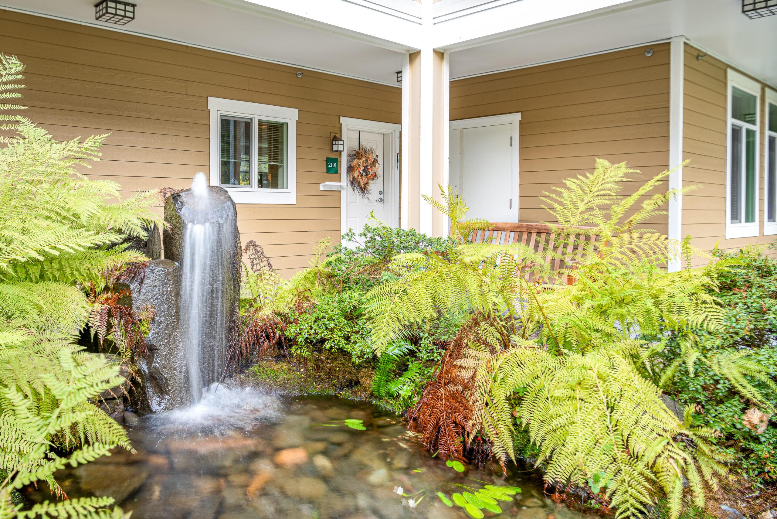 An outdoor fountain surrounded by greenery at Cascade Manor.