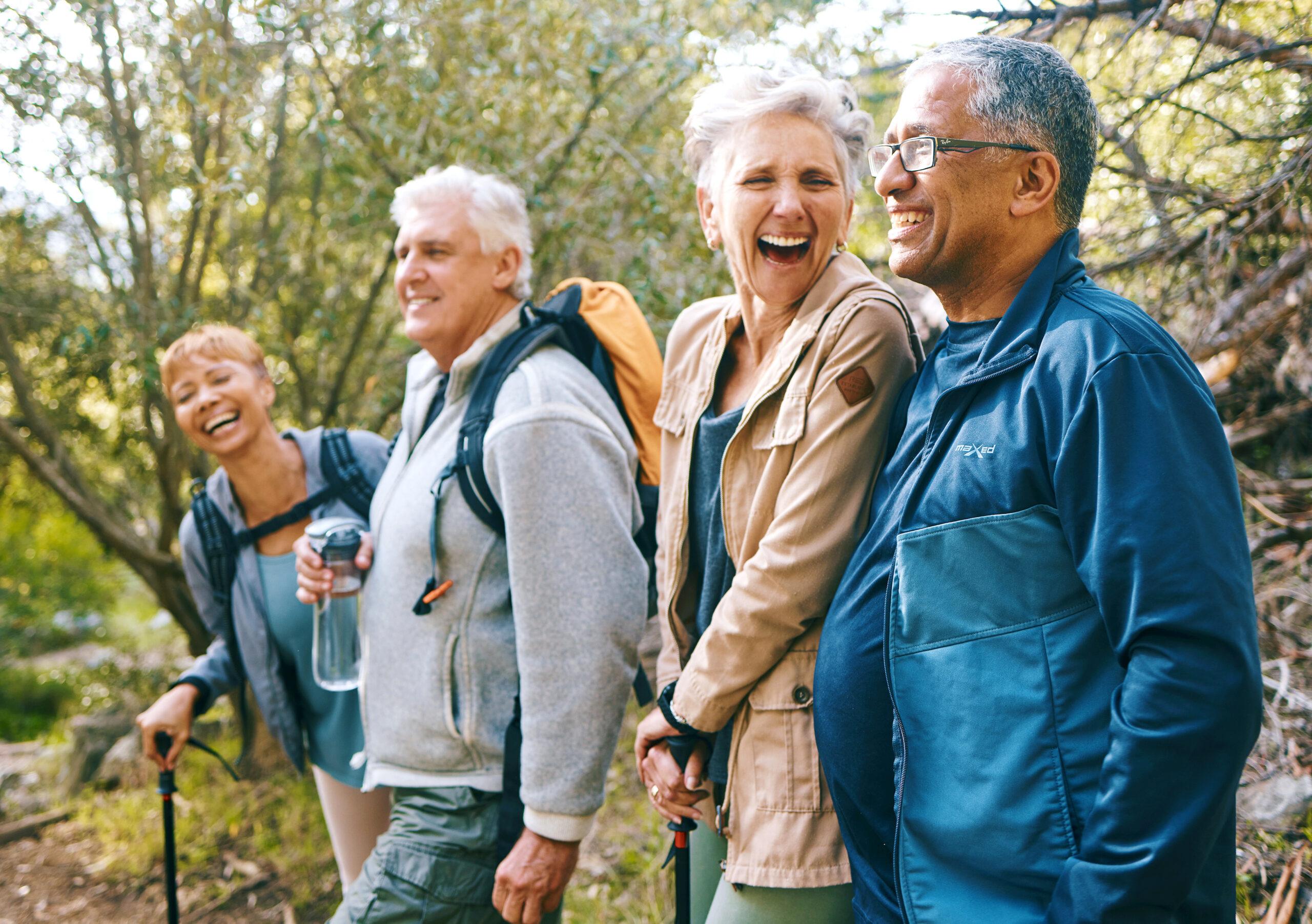 A group of hiking friends laughs and talks outdoors.