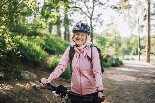 An older woman smiles for the camera during a bike ride.